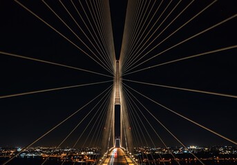 Naklejka premium Nighttime CableStayed Bridge, Cityscape, Starry Sky, Illuminated