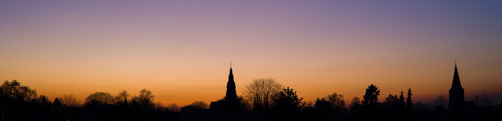 Obraz premium sunset at the blue hour with the panorama skyline of the two churches of ratingen homberg with colored sky 