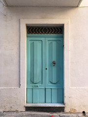 Elegant turquoise Maltese Wooden Door - charming blue wooden door found in Malta, reflecting the island’s rich cultural heritage and classic design, ornaments, brass knobs