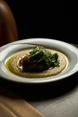 red meat steak with mashed potatoes on a white olate on a black background 