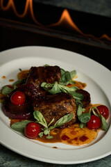 a red meat steak with vegetables on a white plate