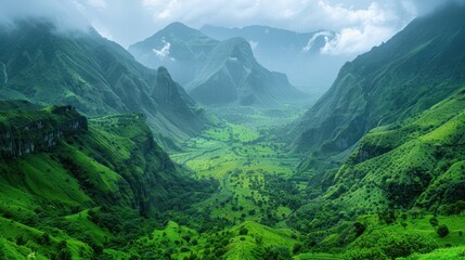 Naklejka premium Green valley between misty mountains with cloudy sky