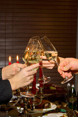 people are cheering with glasses of champagne on a background of red candles 
