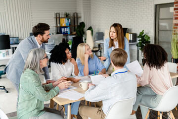 Professional team engaged in group discussion during an office meeting in a modern workspace promoting collaboration and teamwork