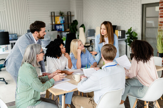 Professional team engaged in group discussion during an office meeting in a modern workspace promoting collaboration and teamwork