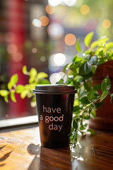 Iced coffee with "Have a good day" message on a wooden table, perfect for cafe marketing.
