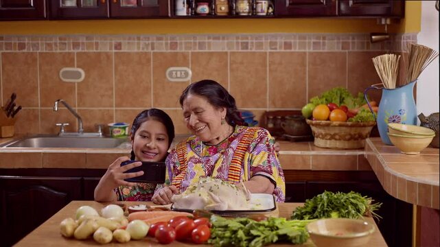 Granddaughter takes a selfie with her grandmother, both cooking a delicious dish for the party.