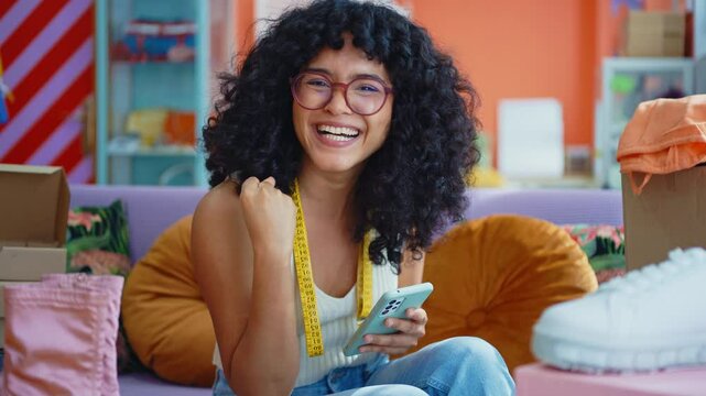 Beautiful young hispanic woman managing her home clothing e-commerce business from home - Female designer owns online shopping store, concepts of home business and reselling second hand accessories