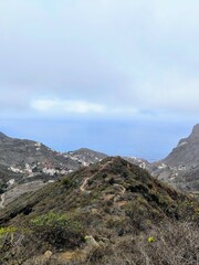 Tenerife’s arid mountain landscape features rugged rock formations covered in hardy succulents....