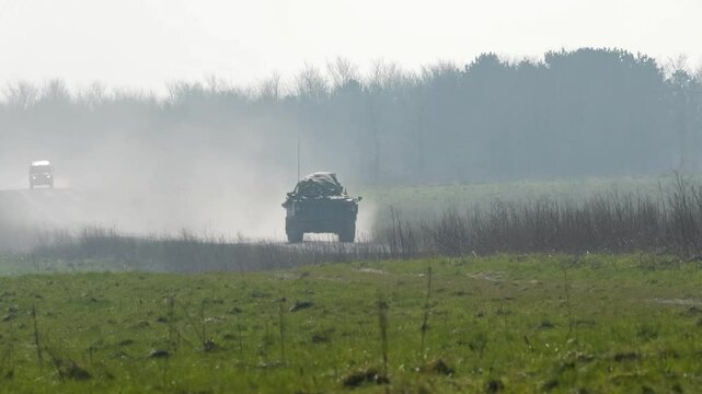 British army FV432 Bulldog tracked tank moving at high speed along a dusty track
