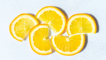 Vitamin C cosmetics ingredient. An arrangement of fresh orange slices on a bright surface,...