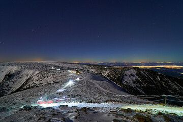 Mountaineers going along the trail during night hike, reaching the summit