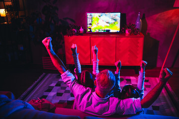 Family enjoying a bonding moment with entertainment in a cozy living room setting, celebrating...