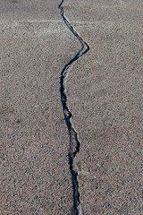 Large and deep crack in the asphalt road surface