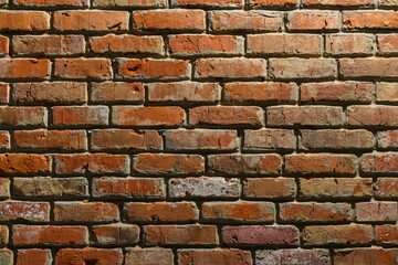Red brick wall with textured surface relief. Brickwork close-up, natural background