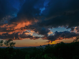 A mostly red afterglow casted on big dense clouds by the light of  the sunset, over the western Andean mountains of central Colombia, near the town of Villa de Leyva.