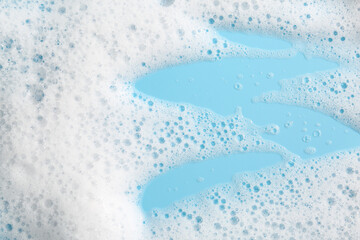 Detergent foam with bubbles on light blue background, above view
