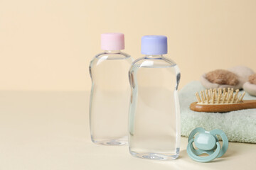Baby oil and bath accessories on color background