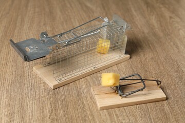 Two different mouse traps with bait on floor, closeup