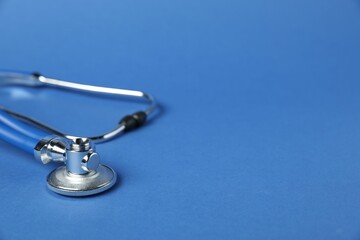 Stethoscope on blue background, closeup. Space for text