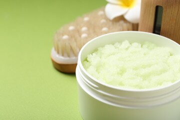 Body care product in jar on green background, closeup. Space for text
