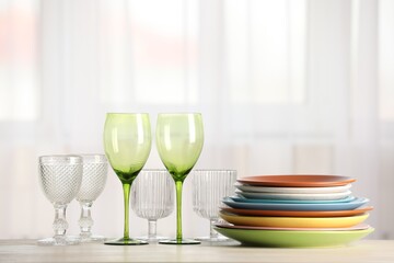 Empty clean glasses and plates on table indoors