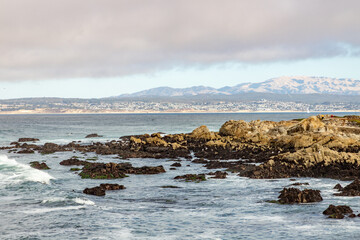 Clouds and waves in rocky beach