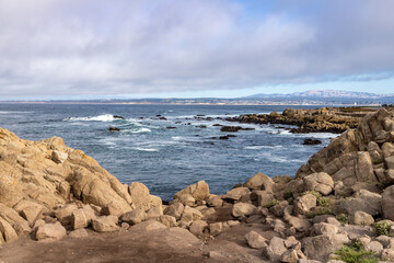 Clouds and waves in rocky beach
