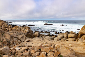 Clouds and waves in rocky beach
