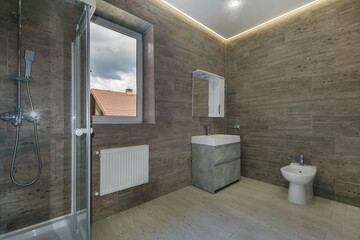 Modern bathroom design, decorated with tiles in gray tones. Glass shower cabin, mirror over the...