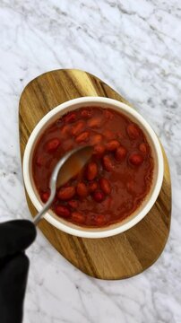 mixing and eating warm delicious beans on a bowl