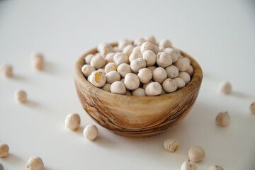 Roasted white chickpeas in wooden bowl, traditional Turkish nut on white background. Turkish leblebi, famous nut.