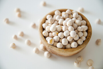 Roasted white chickpeas in wooden bowl, traditional Turkish nut on white background. Turkish leblebi, famous nut.