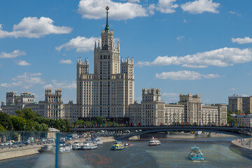 Kotelnicheskaya embankment building dominating moscow cityscape with boat cruising moskva river