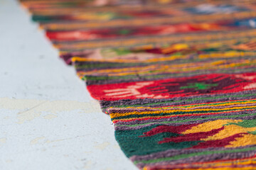 Close-up image of a colorful, patterned textile with an intricate design and soft, dense weave The...