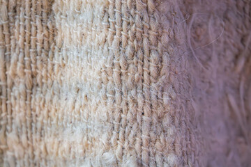 Image displays a close-up view of a hand-stitched fabric with color gradient thread, focusing on the textures and stitching details