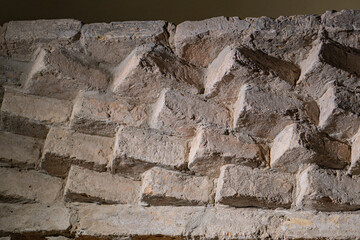 Close-up of weathered, aged brick structure with a zigzag pattern