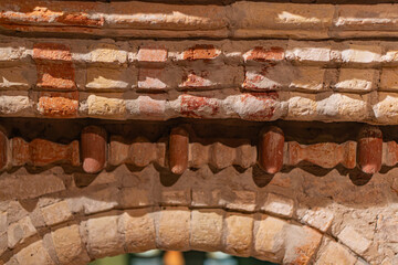 Close-up view of a brick archway, with alternating colors and textures Visible crack, sunlight casting shadows, no texts present
