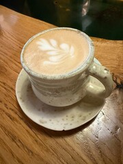 Rustic Cappuccino with Latte Art in a Handmade Ceramic Cup on Wooden Table