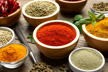 Different aromatic spices on wooden table, closeup