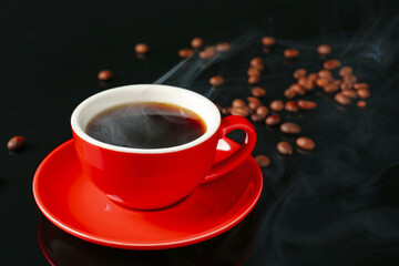 Red cup with coffee and roasted beans on black background, closeup. Space for text