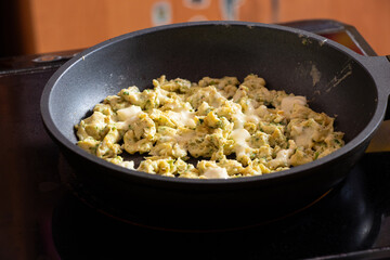 Fried eggs in a frying pan in the kitchen on an induction stove
