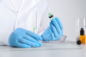 Fototapeta premium Laboratory testing. Scientist working with test tube at white marble table, closeup