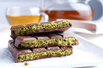 Pieces of delicious Dubai chocolate with pistachios and knafeh on table, closeup