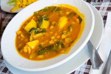 Traditional Spanish hearty soup from chickpea served in white plate