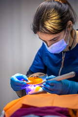 Dental fillings. Dental fillings with ultraviolet light. Female dentist treating a girl's tooth.