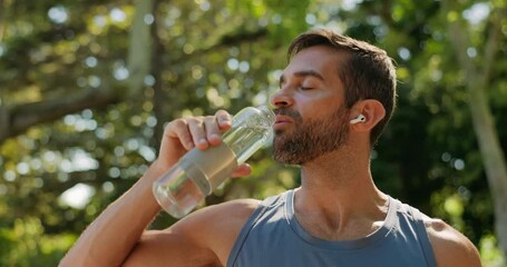 Thirsty, athlete and drinking water, man and hydration for runner with earphones, outdoor and healthy. Nature, wellness and person with liquid on break, metabolism and fitness with beverage or music