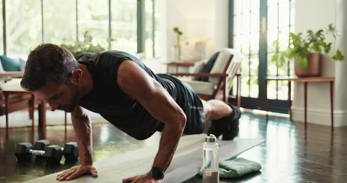 Health, fitness and man with push ups in home for morning workout in living room with challenge. Sports, balance and person with training routine for core strengthening exercise on yoga mat in house.