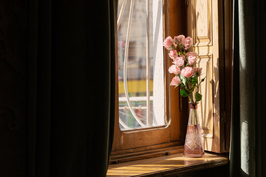 still life with flowers in vase on window background
