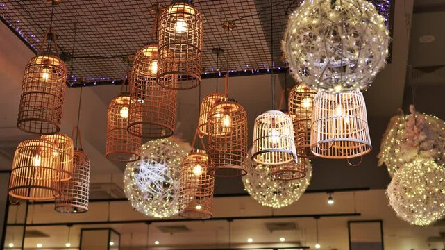 Wicker lamps and led spheres hanging from ceiling illuminating restaurant